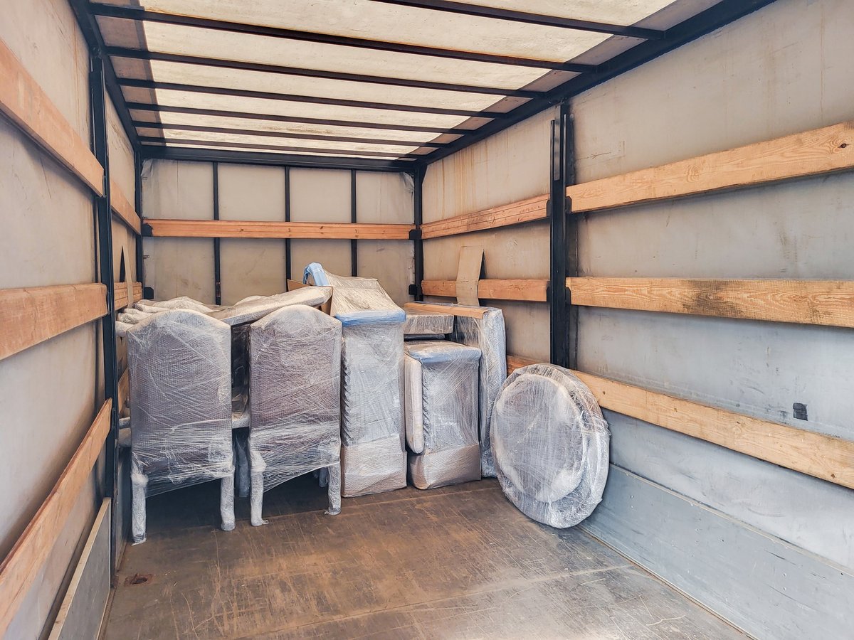 Packed furniture and boxes prepared for removal inside a truck cargo